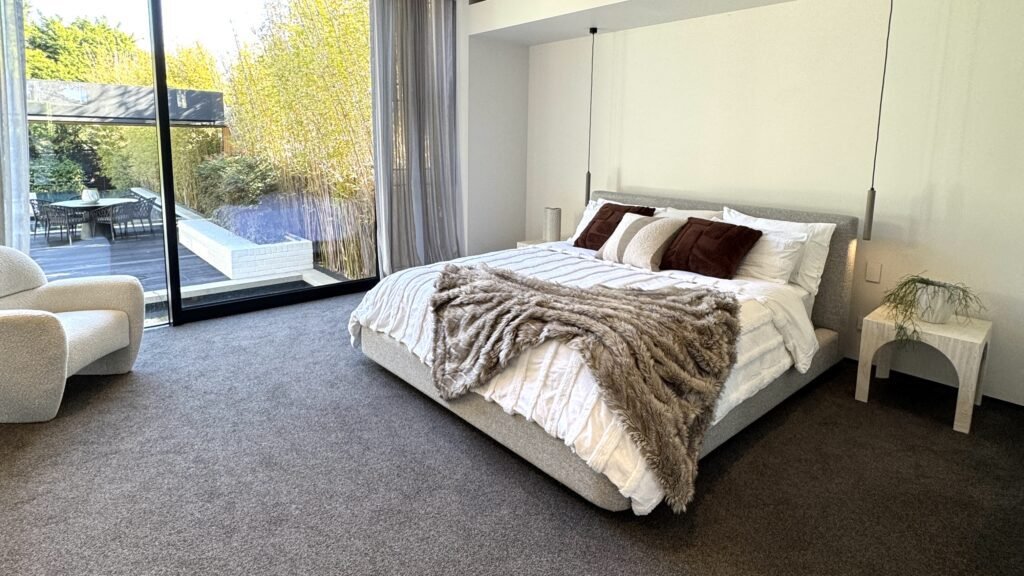 Modern bedroom interior with neutral palette, soft textures, and natural light