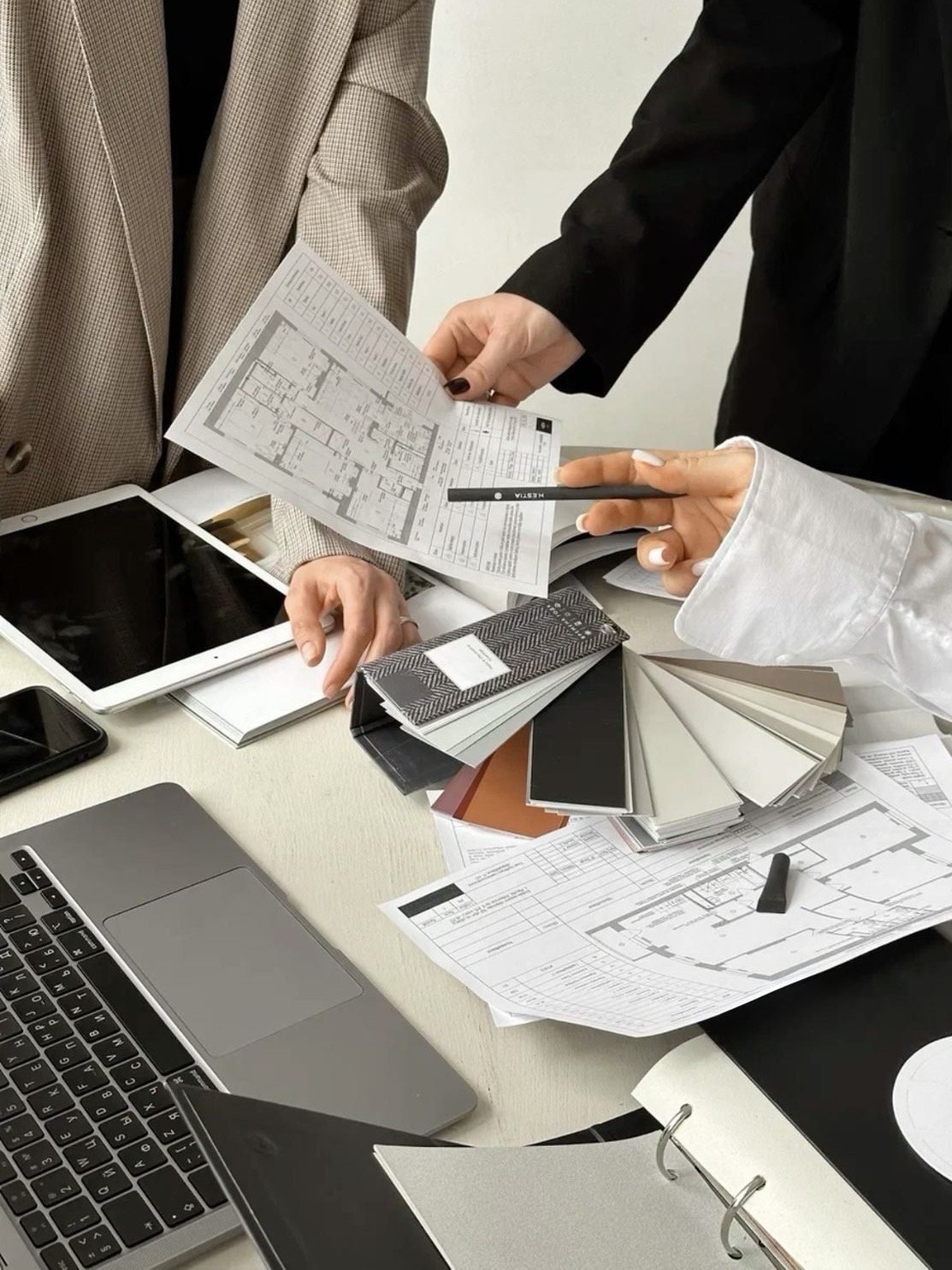 Interior design consultation by ODesign with designers reviewing floor plans, material samples, and finishes during the design process